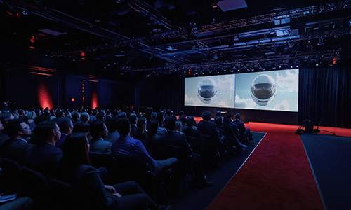 Audience in the ceremony hall facing two large screens