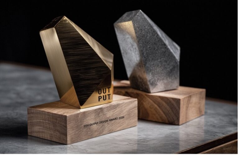 Gold and silver Output Design Award trophies on wooden bases